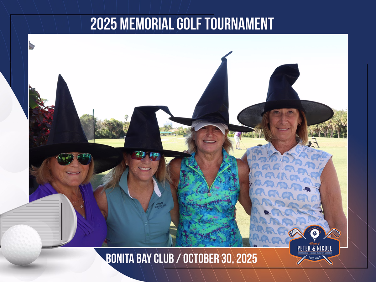 A group of four women smiling in a roaming camera with a custom frame wearing halloween hats