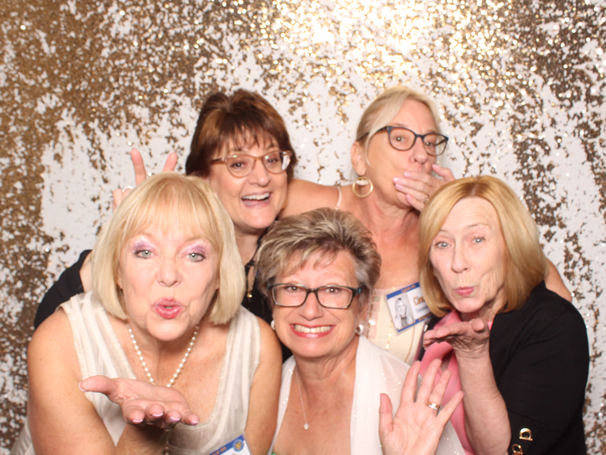 Group of friends, including Deb Newman of Photo Magic Events posing in a photo booth rental