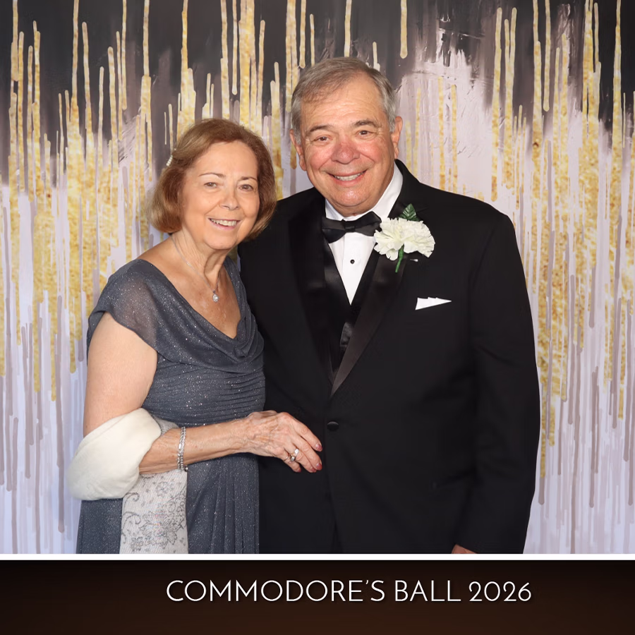 A couple smiling in a Photo Booth with a custom frame at a ball