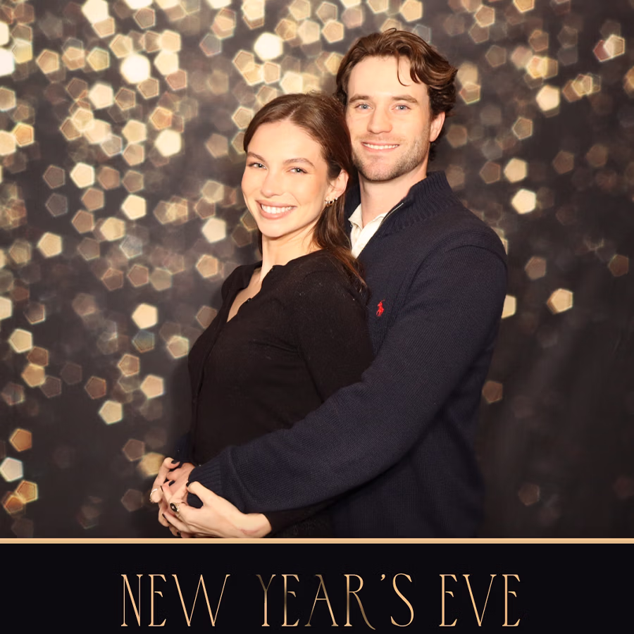 A couple smiling in a Photo Booth with a custom background and frame