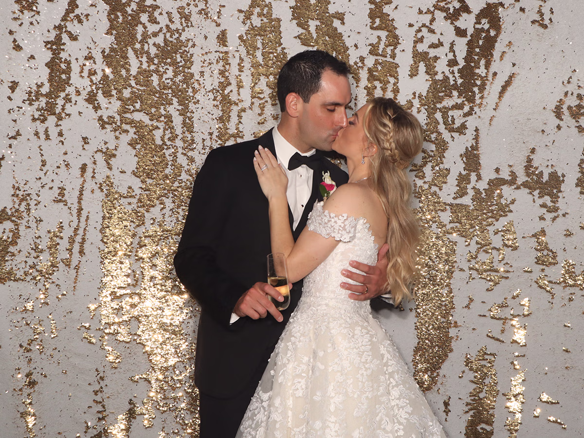 A bride and groom kissing in the Photo Magic Event photo booth rental in southwest florida