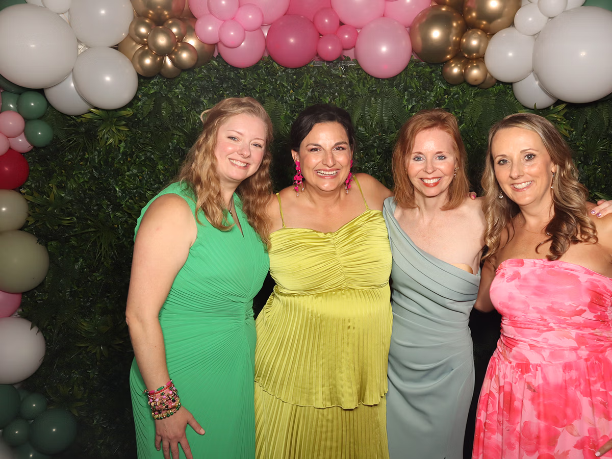 Group of women at a fundraising event using the fundraiser photo booth rental provided by Photo Magic Events
